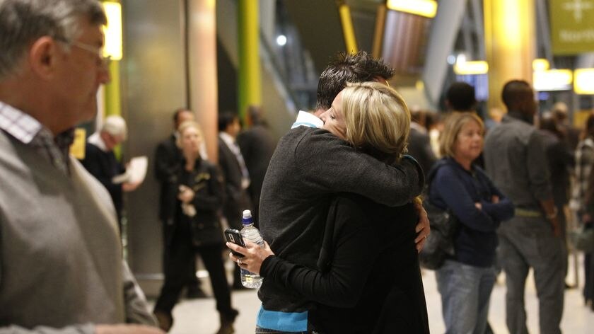 Reunited at last: Richard Young hugs his wife Sarah as she arrives at Heathrow after being stranded in Vancouver