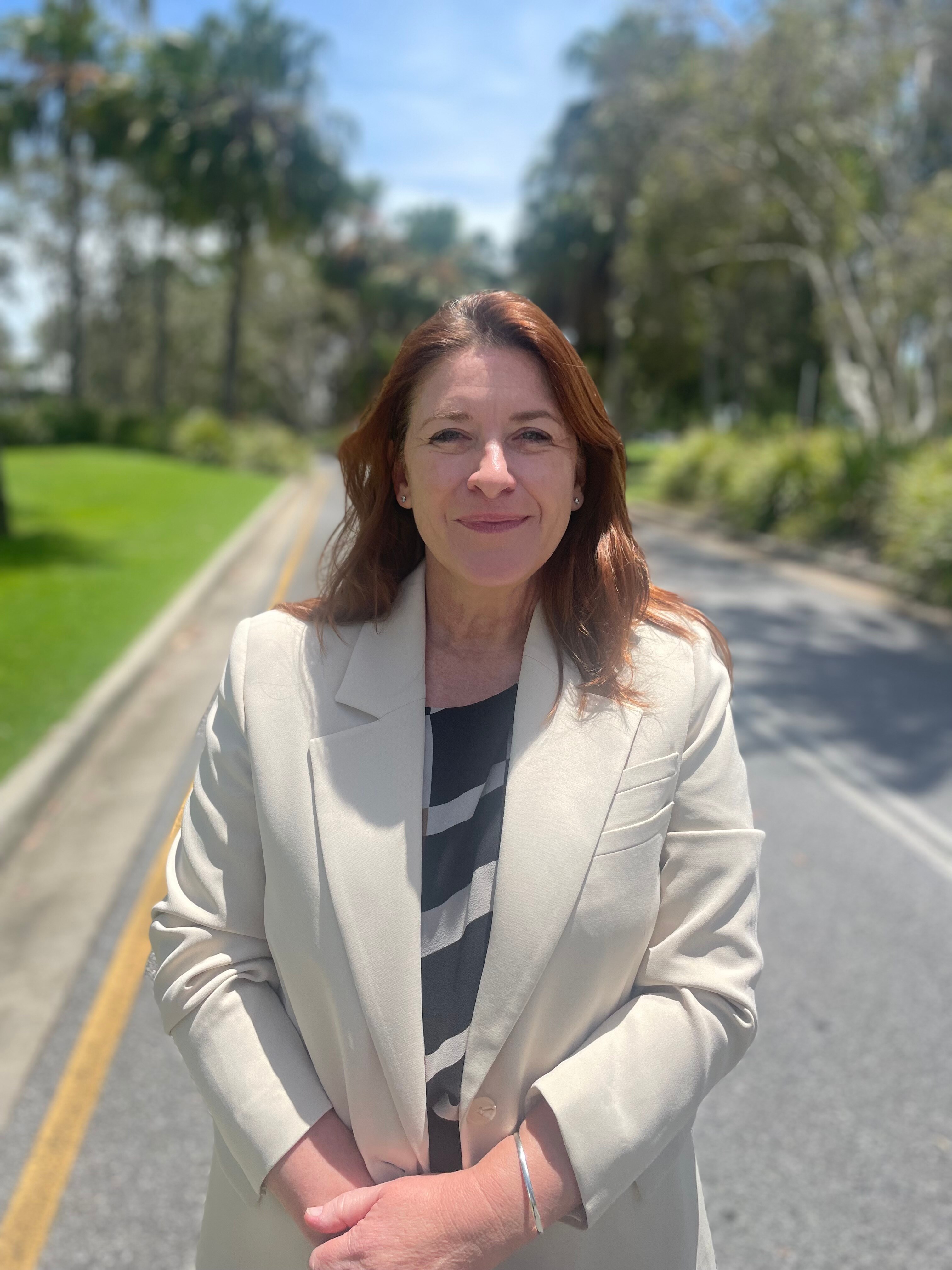 Woman in white jacket on road