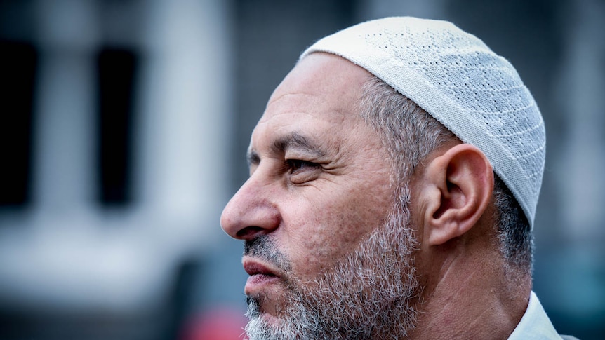A man wearing a small religious head cap stares into the distance.