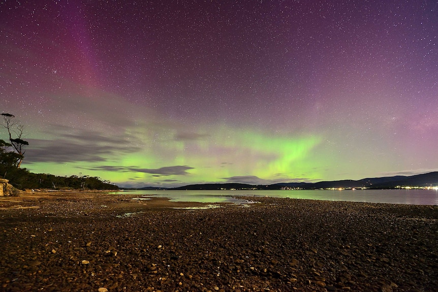 Green and purple lights in the sky above a lake