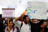 Students carry signs and shout during a protest march.
