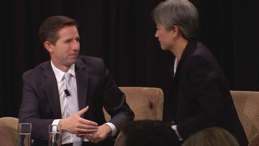 Simon Birmingham holds out his hand as Penny Wong looks at him refusing to shake it