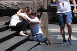 People are seen hugging on the corner of Bourke and Elizabeth street after a rogue car ploughed into pedestrians.