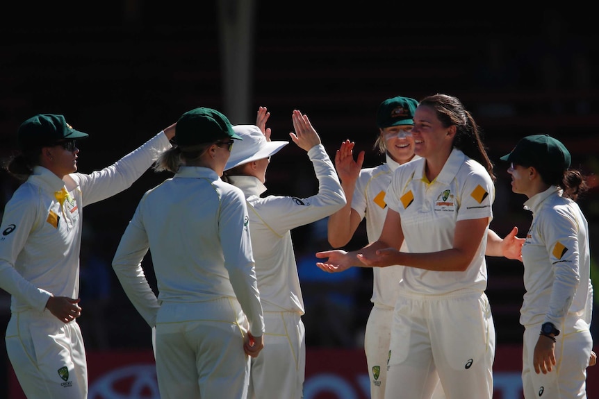 Tahlia McGrath receives congratulations from her Australia teammates after claiming an England wicket.