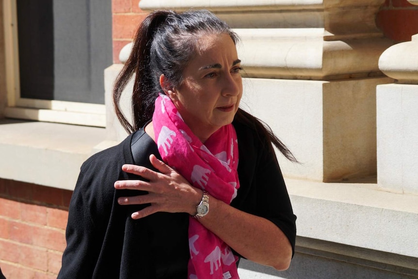 A mid shot of state prosecutor Carmel Barbagallo SC outside the Supreme Court in Perth wearing a black top and pink scarf.