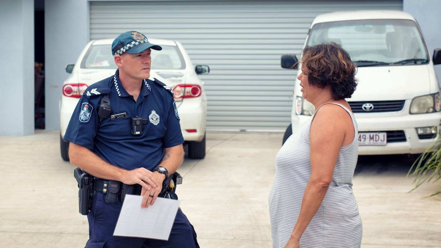 Police officer speaking to woman.