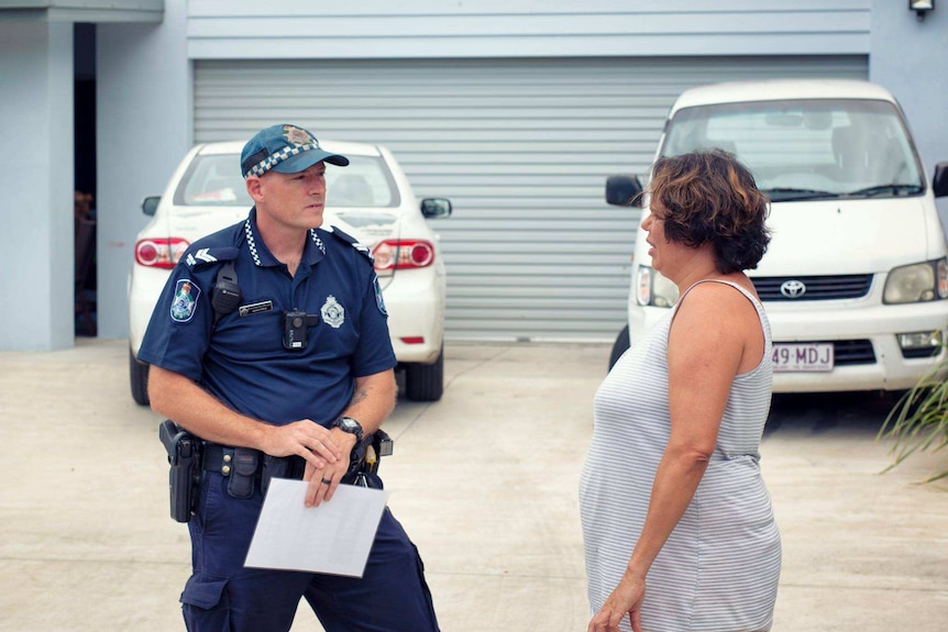 Police officer speaking to woman.