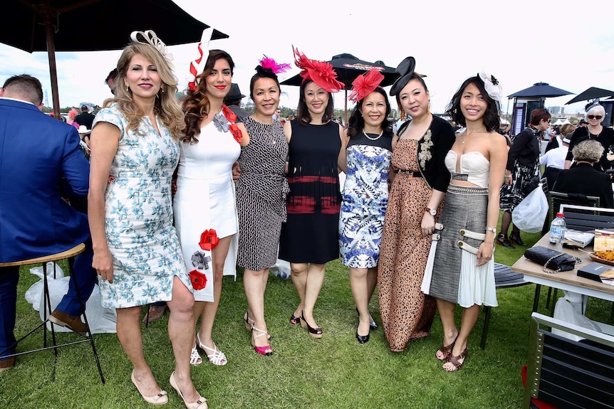 多名来自亚洲和澳大利亚的女性穿戴华丽，出席墨尔本杯现场。