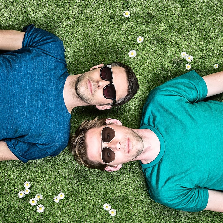 The two members of Groove Armada lie on the grass