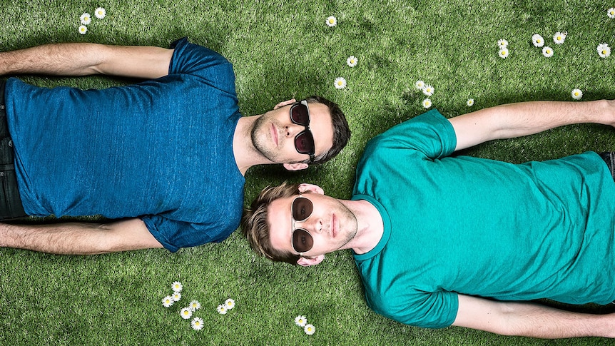 The two members of Groove Armada lie on the grass