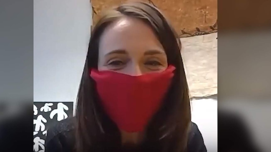 New Zealand Prime Minister Jacinda Ardern wears a red face mask.