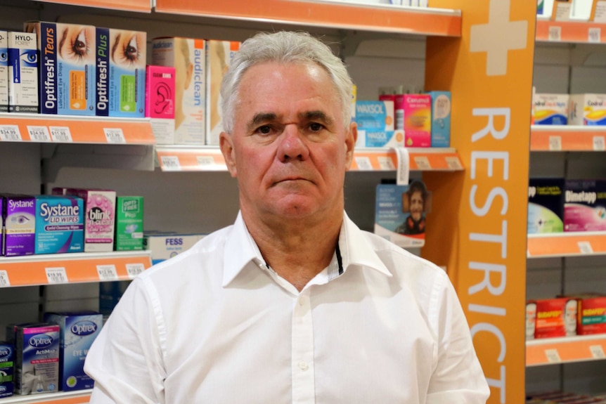 Mr Tweedie stands in front of a row of medications.