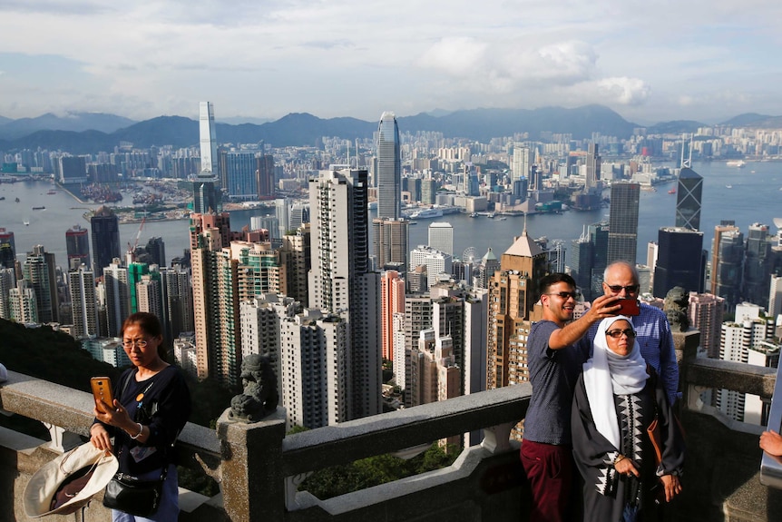 Tourists take selfies at the Peak in Hong Kong, China.