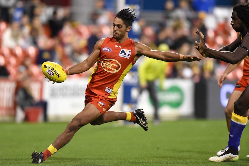 Aaron Hall kicks the ball for Gold Coast against West Coast