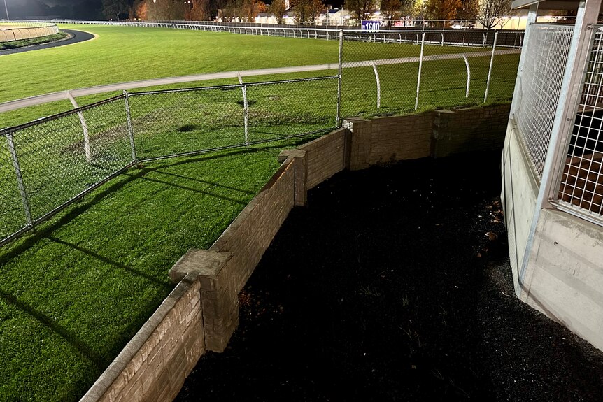 A wall alongside a grass track