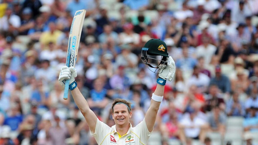 Steve Smith lifts his bat and helmet into the air to celebrate scoring a century.