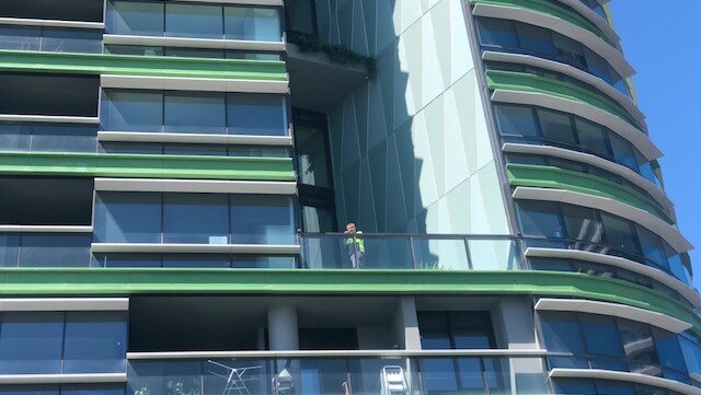 man standing on balcony of apartment complex