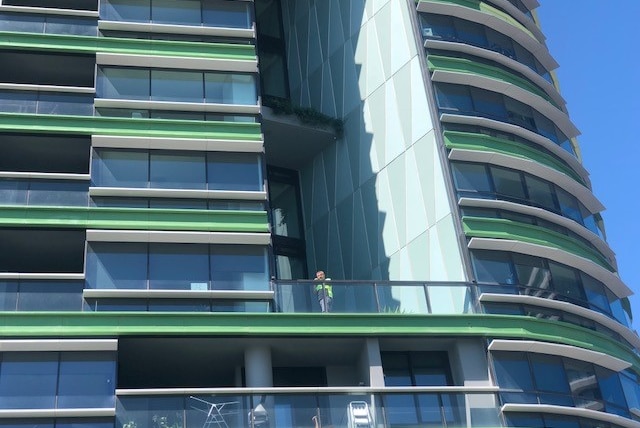 man standing on balcony of apartment complex