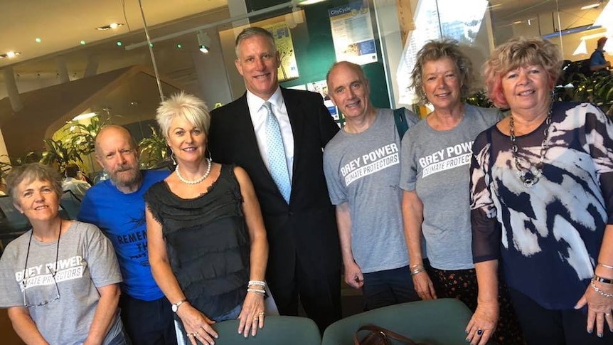 A group of smiling people standing in a meeting room