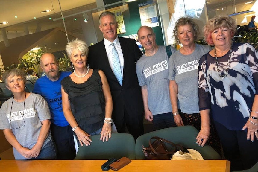 A group of smiling people standing in a meeting room