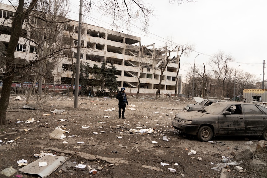 A person stands amid rubble of an airstrike on Pryazovskyi State Technical University.