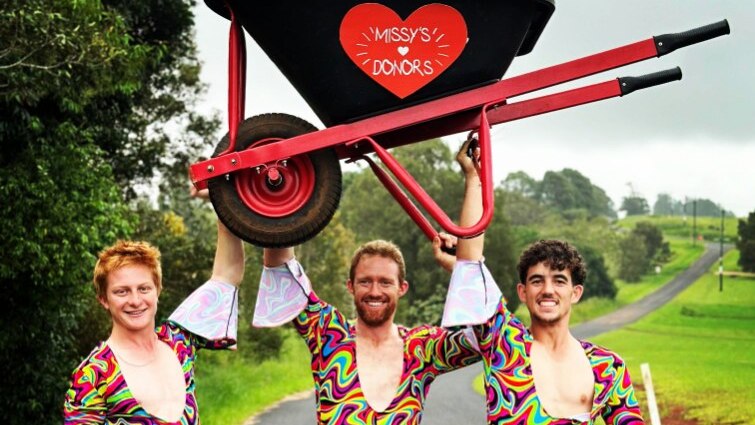 Three men in outrageously colourful one piece suits get ready to do a charity event.
