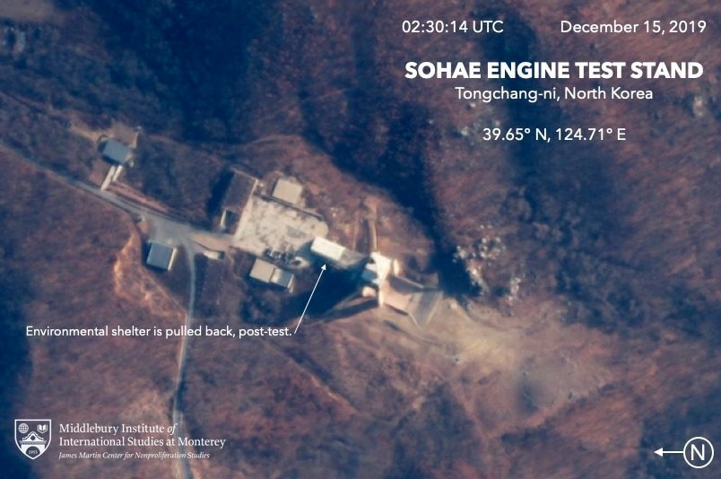 A satellite image shows an aerial shot of an environmental shelter is pulled back, shows an engine test stand.