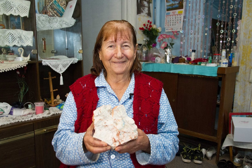 A woman holding an opal stone