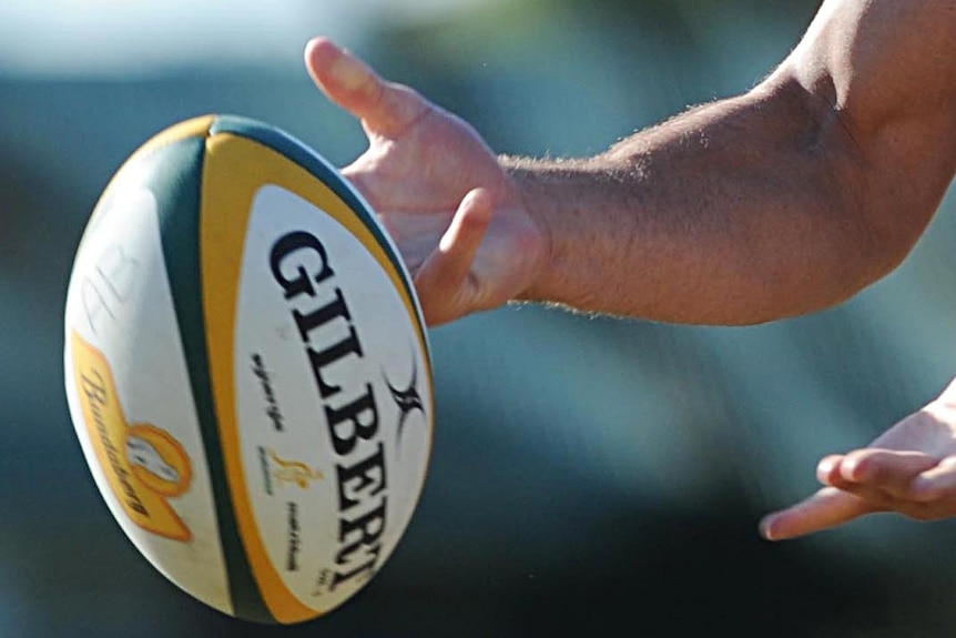 A rugby union player passes the ball.