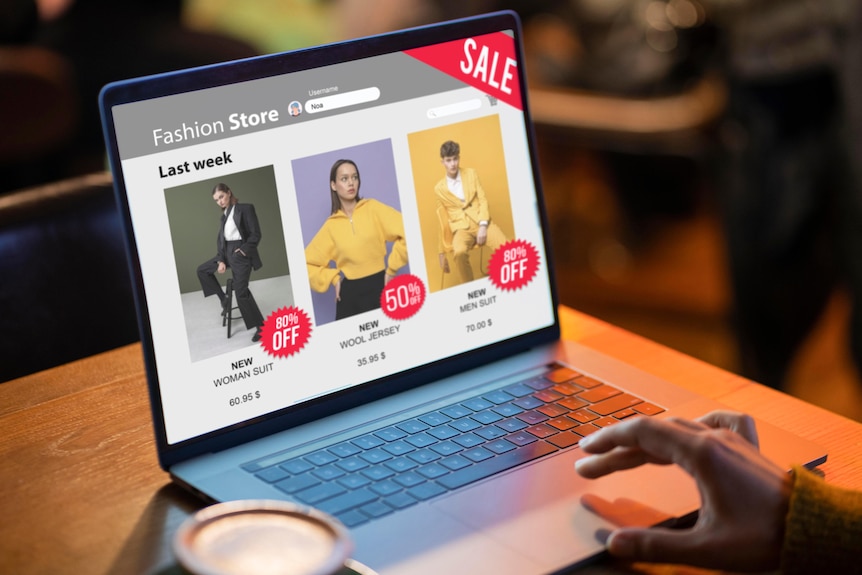 A person on their laptop on a clothing shop website that has sales on