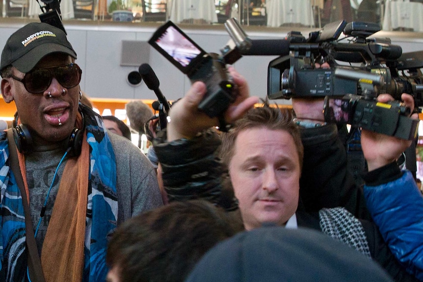 Entrepreneur Michael Spavor, centre, is seen with former NBA star Dennis Rodman on the way to a flight to North Korea.