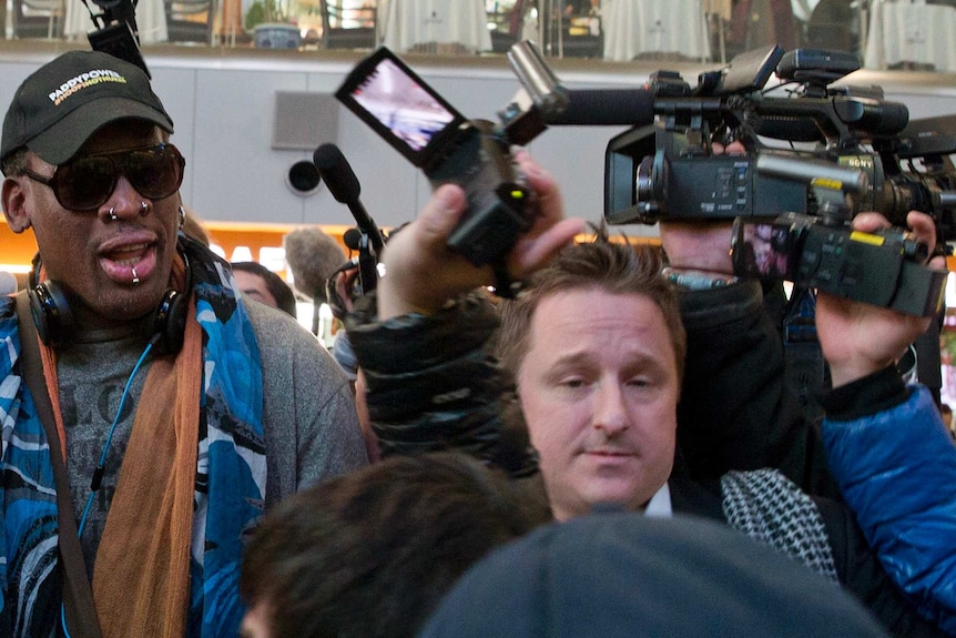 Michael Spavor, center, an entrepreneur, is seen with former NBA star Dennis Rodman on the way to a flight to North Korea.