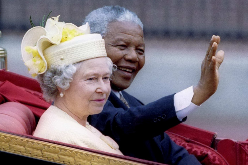 Nelson Mandela and Queen Elizabeth II ride in a carriage outside Buckingham Palace
