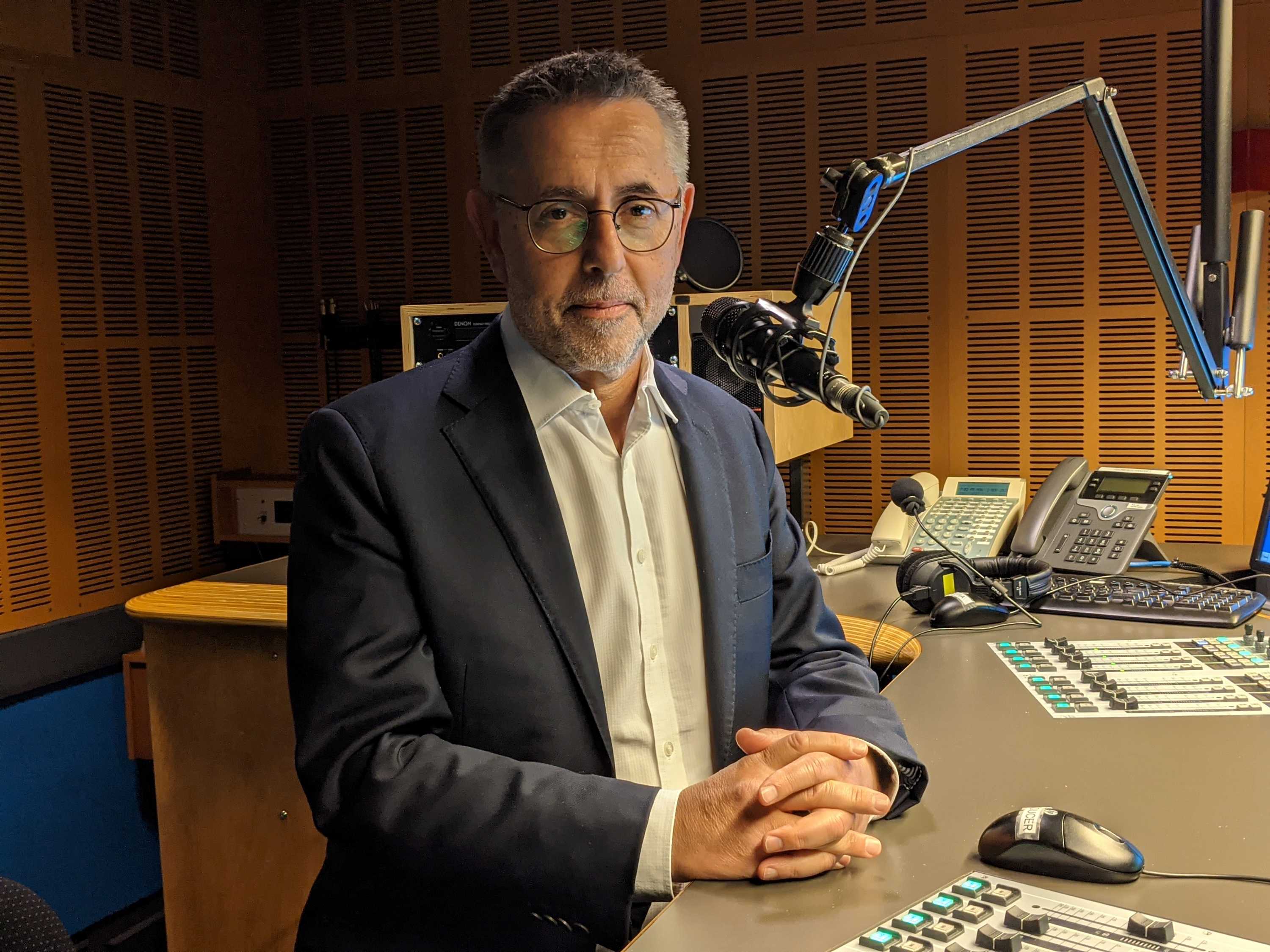 Swan in radio studio with microphone in front of his face.