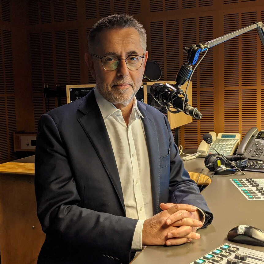Swan in radio studio with microphone in front of his face.