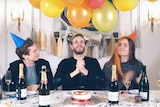 Joel Berghult, Felix Kjelberg and David Brown sit at a party table with balloons