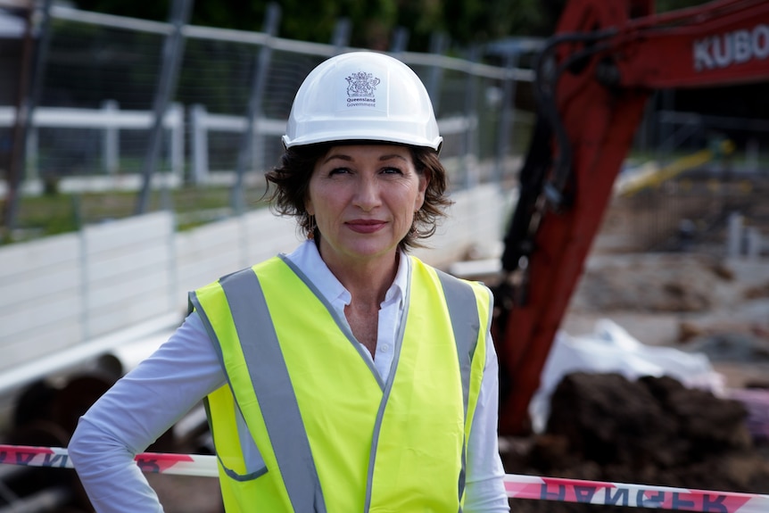 Leeanne Enoch in a high-vis vest and a hard hat with a Queensland Government stamp on it