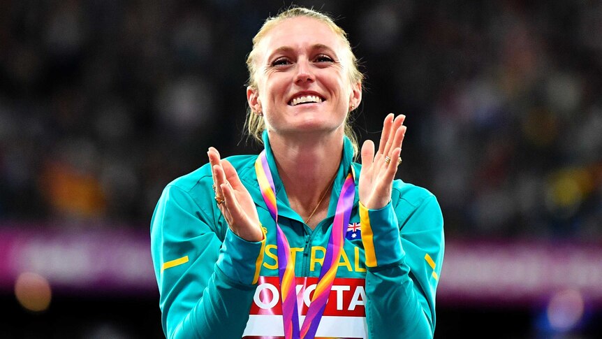 Sally Pearson tears up and claps at the medal ceremony for the 100m hurdles.