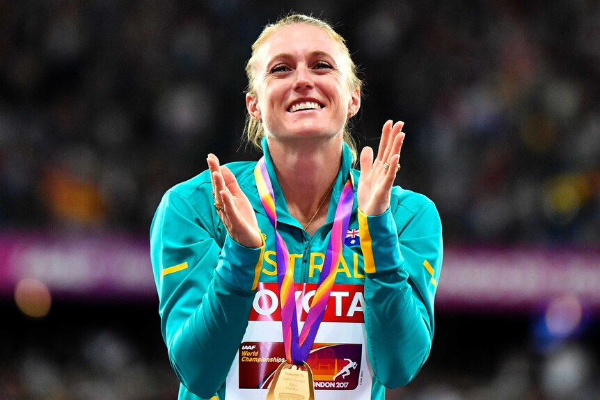 Sally Pearson tears up and claps at the medal ceremony for the 100m hurdles.