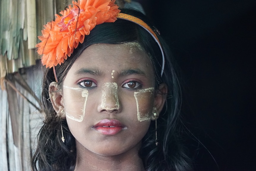 A close up of a girl in Myanmar as she stares at the camera.