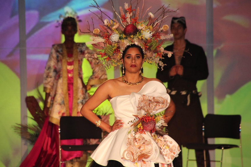 A model on a catwalk wearing an elaborate head dress.