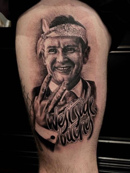 A tattoo of a man in a bandanna on a leg. 
