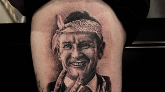 A tattoo of a man in a bandanna on a leg. 