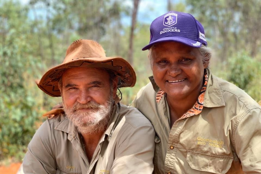 An older, smiling couple ion a bush setting