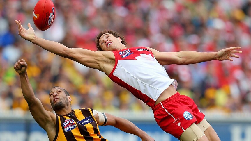 Shane Mumford of the Swans attempts to mark in front of Josh Gibson of the Hawks.