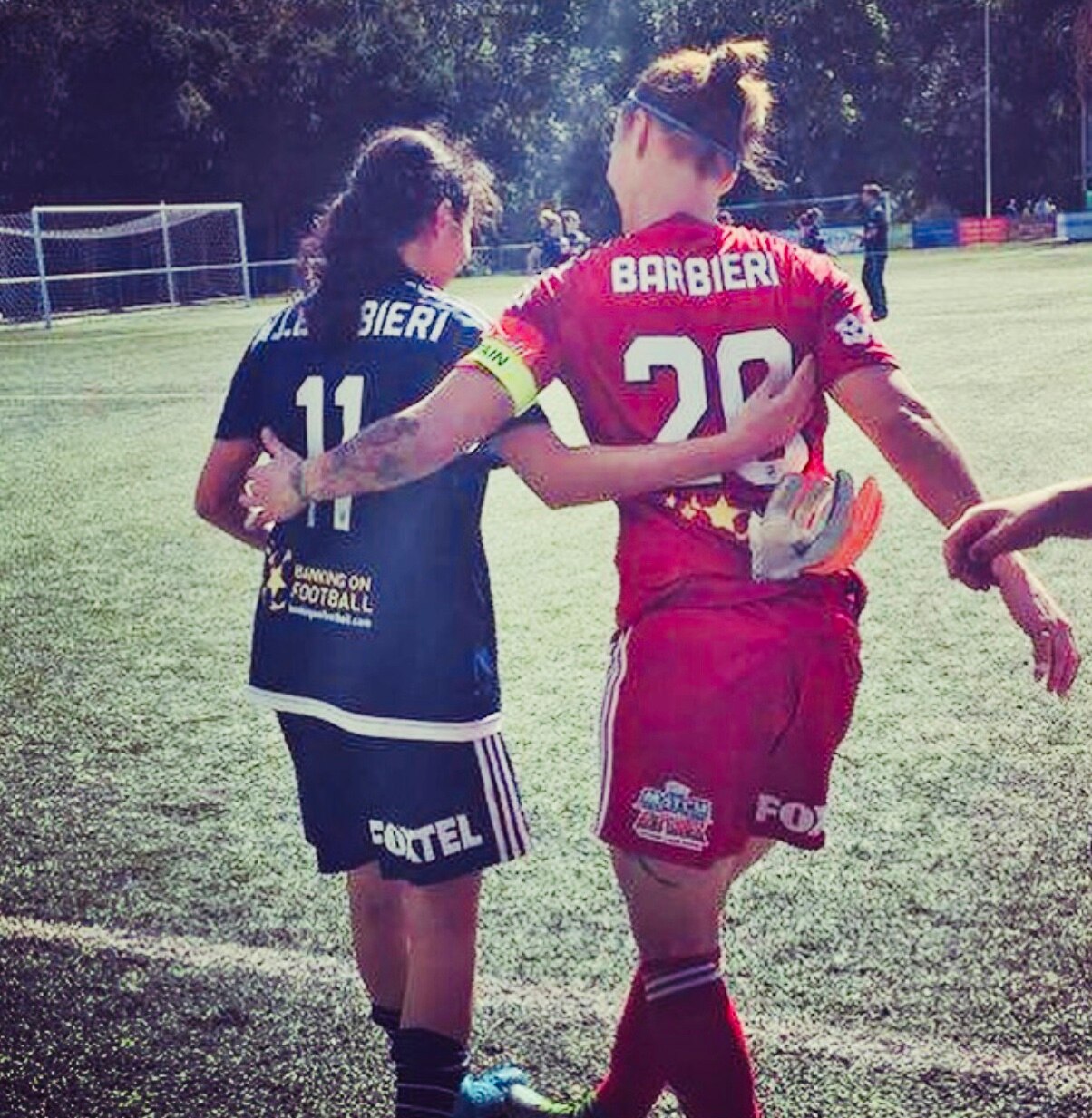 Two female football players kiss after a match.