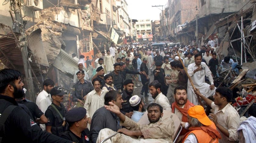 Pakistani volunteers evacuate an injured survivor