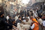 Pakistani volunteers evacuate an injured survivor