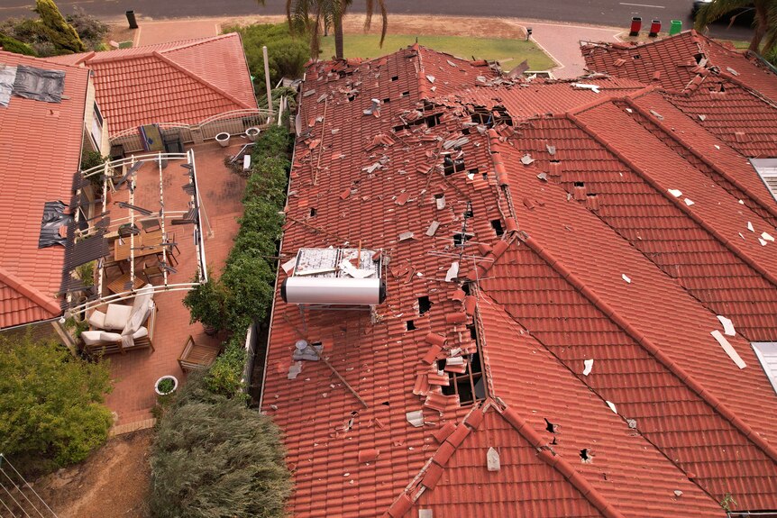 A drone image of a red roof with tiles missing.