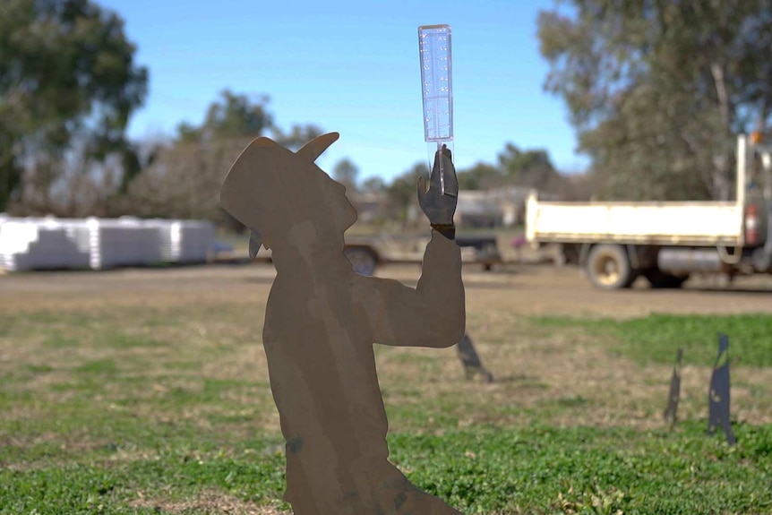 A metal sculpture of a praying farmer